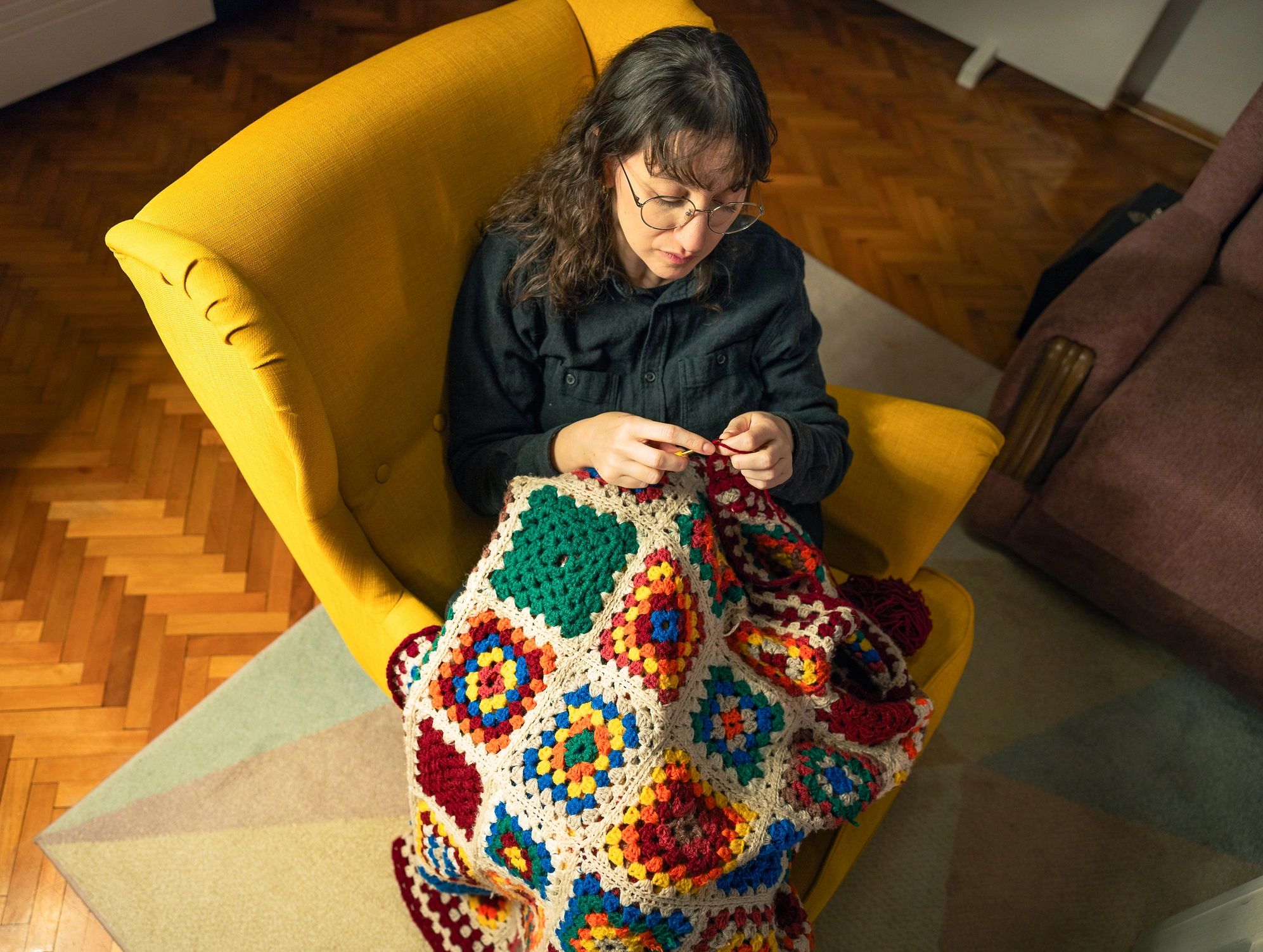 Customer crocheting at home in a cozy chair